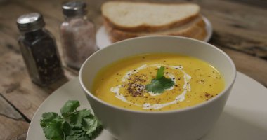 Tahta zemin üzerinde havuç ve ekmek olan havuç çorbası kasesini kapat. Yemek ve ev yapımı çorba..
