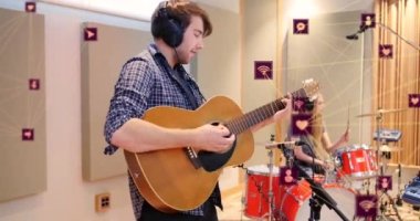 Stüdyodaki provalarda gitar çalan beyaz adamın üzerine bağlı ikonların dünyayı şekillendirmesi. Dijital bileşik, çoklu pozlama, iletişim, küreselleşme, enstrüman ve teknoloji.
