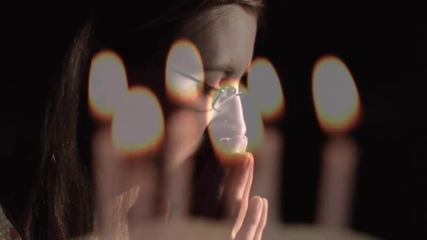 复合视频燃烧蜡烛反对关闭一个高加索女人的祷告 祈祷和宗教概念 — 图库视频影像