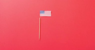 Amerika 'nın ulusal bayrağı ve kırmızı arka planda fotokopi alanı ile asılı duruyor. Amerikan vatanseverliği, bağımsızlık günü ve ulusal bayraklar.
