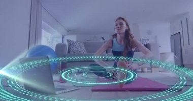 Beyazlı bir kadının laptopunu kullanarak egzersiz yapması üzerine veri işleme animasyonu. Küresel çevrimiçi vloglama, fitness, dijital arayüz ve bağlantılar konsepti dijital olarak oluşturuldu.