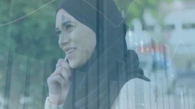 Akıllı telefondan konuşan melez bir kadın için finansal veri işleme animasyonu. Küresel teknoloji, finans ve dijital arayüz kavramı dijital olarak oluşturulmuş video.