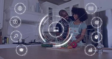 Afro-Amerikan çiftin mutfakta birbirini sevmesi ve veri işleme ikonlarının canlandırılması. Küresel yaşam tarzı, hesaplama, dijital arayüz ve veri işleme kavramı dijital olarak oluşturuldu.