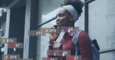 Akıllı telefon kullanan Afro-Amerikan kadının sosyal medya simgelerinin ve numaralarının animasyonu. Küresel sosyal medya, iş dünyası, bulut hesaplama ve veri işleme kavramı dijital olarak oluşturulmuş video.
