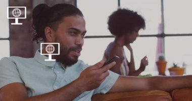 İkonlar ve veri işleme animasyonları çift ırklı iş adamının ofisinde. Küresel iş, finans, hesaplama ve veri işleme kavramı dijital olarak oluşturulmuş video.