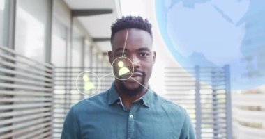 Afro-Amerikan iş adamının ofisindeki simge ve veri işleme animasyonları. Küresel iş, finans, hesaplama ve veri işleme kavramı dijital olarak oluşturulmuş video.