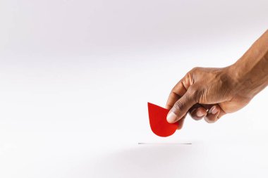 Kan damlasını yukarda tutan melez bir adamın eli beyaz arka planda fotokopi alanı ile birlikte. Kan bağışı, kan bankası, ilaç ve sağlık hizmetleri.