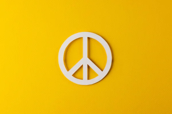 黄色の背景にコピースペースと白の平和サインの高い角度ビュー 平和と反戦運動の概念 — ストック写真
