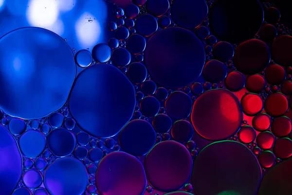 Macro close up of water bubbles with copy space over blue and red background. Macro, colour, water, shape and pattern concept.