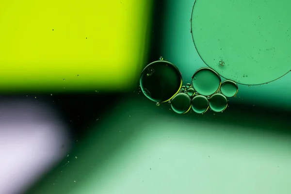 Macro close up of water bubbles with copy space over green background. Macro, colour, water, shape and pattern concept.