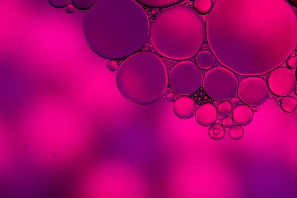 Macro close up of water bubbles with copy space over pink background. Macro, colour, water, shape and pattern concept.
