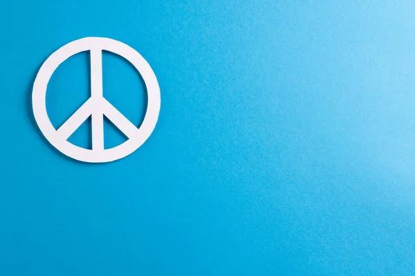 青の背景にコピースペースと白の平和サインの高い角度ビュー 平和と反戦運動の概念 — ストック写真