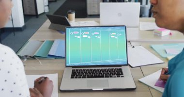Ofisinde medya simgeleri olan birçok iş adamı dizüstü bilgisayar kullanıyor. İş, finans ve dijital arayüz.