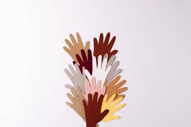 Kağıt, çok renkli ellerden kesilmiş ve beyaz zemin üzerinde fotokopi alanı var. İnsani yardım, insanlar, yardım ve insan kavramı.