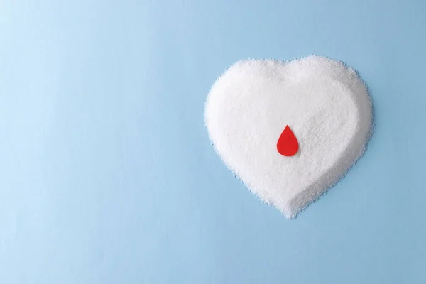 心臓の形の砂糖の上に血がコピースペースと青の背景に落ちる 血糖値 糖尿病 心臓の健康意識 — ストック写真