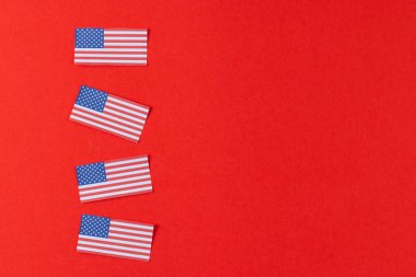 Amerika Birleşik Devletleri 'nin kırmızı arka planında dört bayraklı yüksek açılı görüntüsü. Amerikan vatanseverliği, bağımsızlık günü ve gelenek kavramı.