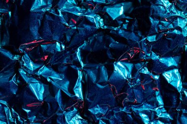 Fotokopi alanı olan buruşuk mavi ve kırmızı folyoyu kapat. Renk, doku ve malzeme.