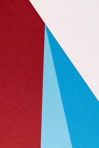 Close up of white and blue paper on red background with copy space. Colour, texture and material.
