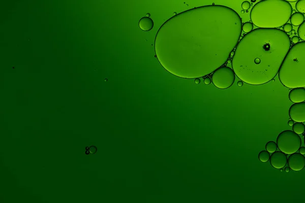 Macro close up of water bubbles with copy space on green background. Macro, colour, water, shape and pattern concept.