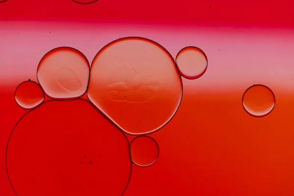 Macro close up of water bubbles with copy space over red background. Macro, colour, water, shape and pattern concept.