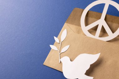 Beyaz barış işareti, beyaz güvercin ve mavi arka planda fotokopi alanı olan bir zarf. Barış ve savaş karşıtı hareket kavramı.