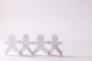 Beyaz arka planda fotokopi alanıyla el ele tutuşan dört kağıt kesimini kapatın. İnsani yardım, insanlar, yardım ve insan kavramı.