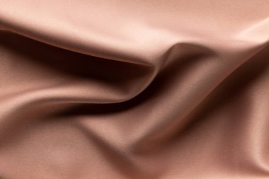 Düz bej kumaşlı katlanmış saten kumaşı kapatın, boşluğu kopyalayın. Renk, doku ve malzeme.