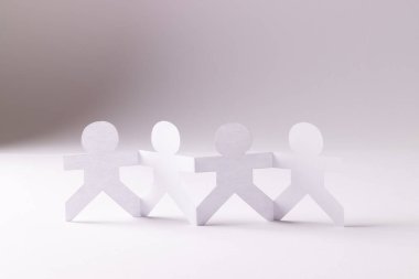 Beyaz arka planda fotokopi alanıyla el ele tutuşan dört kağıt kesimini kapatın. İnsani yardım, insanlar, yardım ve insan kavramı.