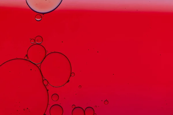 Macro close up of water bubbles with copy space over red background. Macro, colour, water, shape and pattern concept.