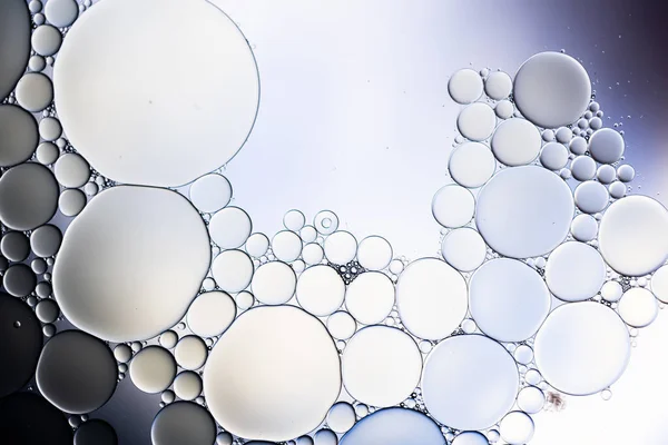 Macro close up of water bubbles with copy space over grey background. Macro, colour, water, shape and pattern concept.