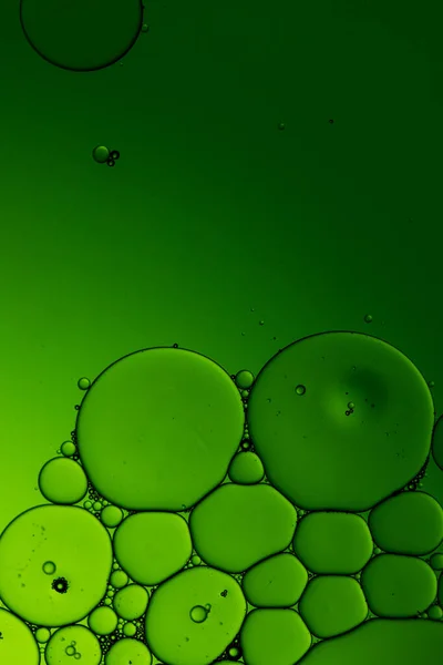 Macro close up of water bubbles with copy space on green background. Macro, colour, water, shape and pattern concept.