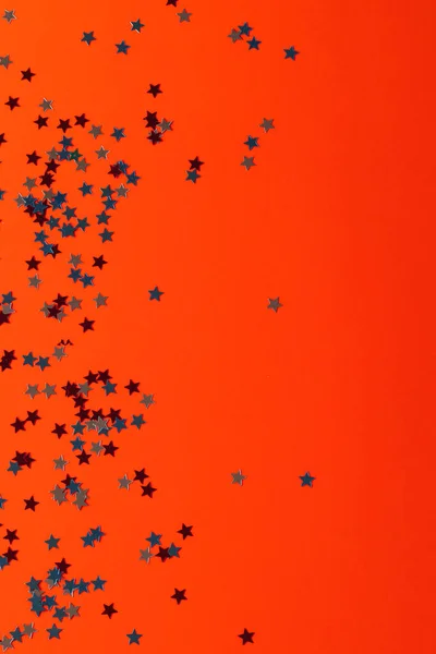 Red, blue and white stars of flag of united states of america with copy space on orange background. American patriotism, independence day and tradition concept.