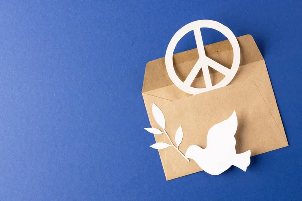 青い背景にコピースペースの白い平和記号 白い鳩と封筒の高い角度ビュー 平和と反戦運動の概念 — ストック写真