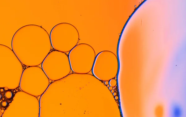 Macro close up of water bubbles with copy space over orange background. Macro, colour, water, shape and pattern concept.