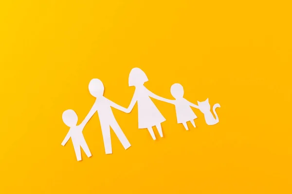 White paper cut out of family with two children and ca and copy space on orange background. Humanitarian aid, people, help and human concept.