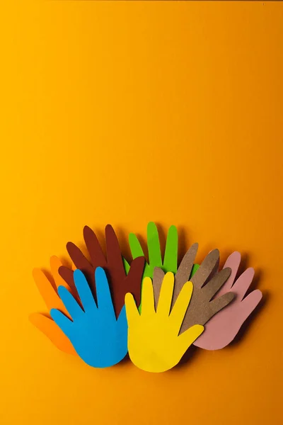 Закрыть Бумагу Вырезанную Разноцветных Рук Пространством Копирования Оранжевом Фоне Гуманитарий — стоковое фото