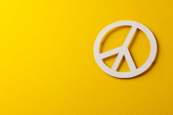 黄色の背景にコピースペースと白の平和サインの高い角度ビュー 平和と反戦運動の概念 — ストック写真