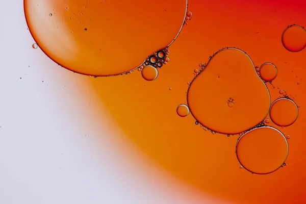 Macro close up of water bubbles with copy space over orange and white background. Macro, colour, water, shape and pattern concept.
