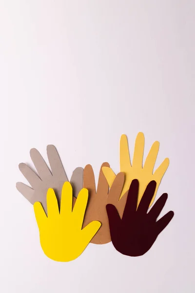 Paper cut out of multi coloured hands with copy space on white background. Humanitarian aid, people, help and human concept.
