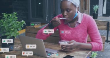 Dizüstü bilgisayar kullanan Afro-Amerikan kadın üzerinde numaraları olan sosyal medya simgelerinin animasyonu. Sosyal medya, iletişim ve dijital arayüz kavramı dijital olarak oluşturulmuş video.