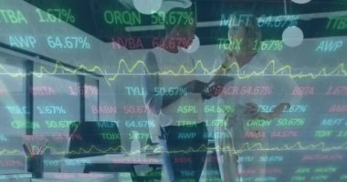 Animation of stock market data processing over two diverse women discussing at office. Global economy and business technology concept