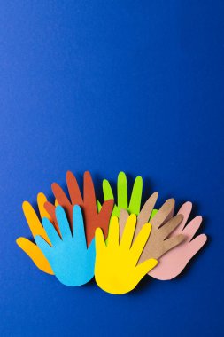 Çok renkli ellerden kesilmiş kağıtları kapatın ve mavi arkaplanda kopya alanı olsun. İnsani yardım, insanlar, yardım ve insan kavramı.