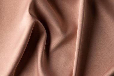 Düz bej kumaşlı katlanmış saten kumaşı kapatın, boşluğu kopyalayın. Renk, doku ve malzeme.