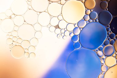 Makro, sarı ve mavi arkaplan üzerinde fotokopi alanı olan su kabarcıklarını kapat. Makro, renk, su, şekil ve şablon kavramı.