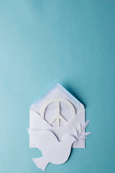 青い背景にコピースペースの白い平和記号 白い鳩と封筒の高い角度ビュー 平和と反戦運動の概念 — ストック写真