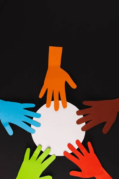 黒い背景にコピースペースのある複数の色の手と白い円から切り取られた紙 人道的 援助的 人間的概念 — ストック写真