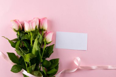 Kurdeleli pembe lalelerin resmi ve pembe arka planda kopya alanı olan kart. Anneler Günü, doğa ve bahar konsepti.