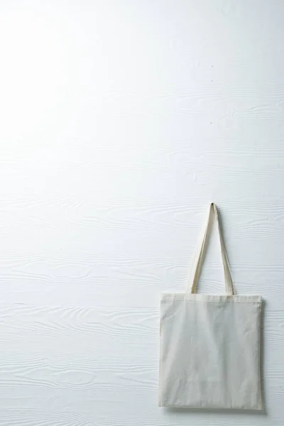 Close up of hanging white canvas bag with copy space on white background. Bags and fashion concept.