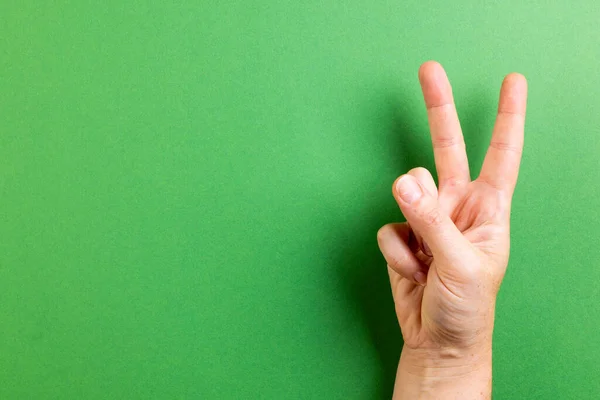 緑の背景にコピースペースで平和サインを示す白人女性の手を閉じてください 平和と反戦運動の概念 — ストック写真
