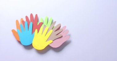Beyaz arkaplanda fotokopi alanı olan renkli kağıtlardan yapılmış elleri birleştirin. Topluluk, küresel, insanlar ve sanat.